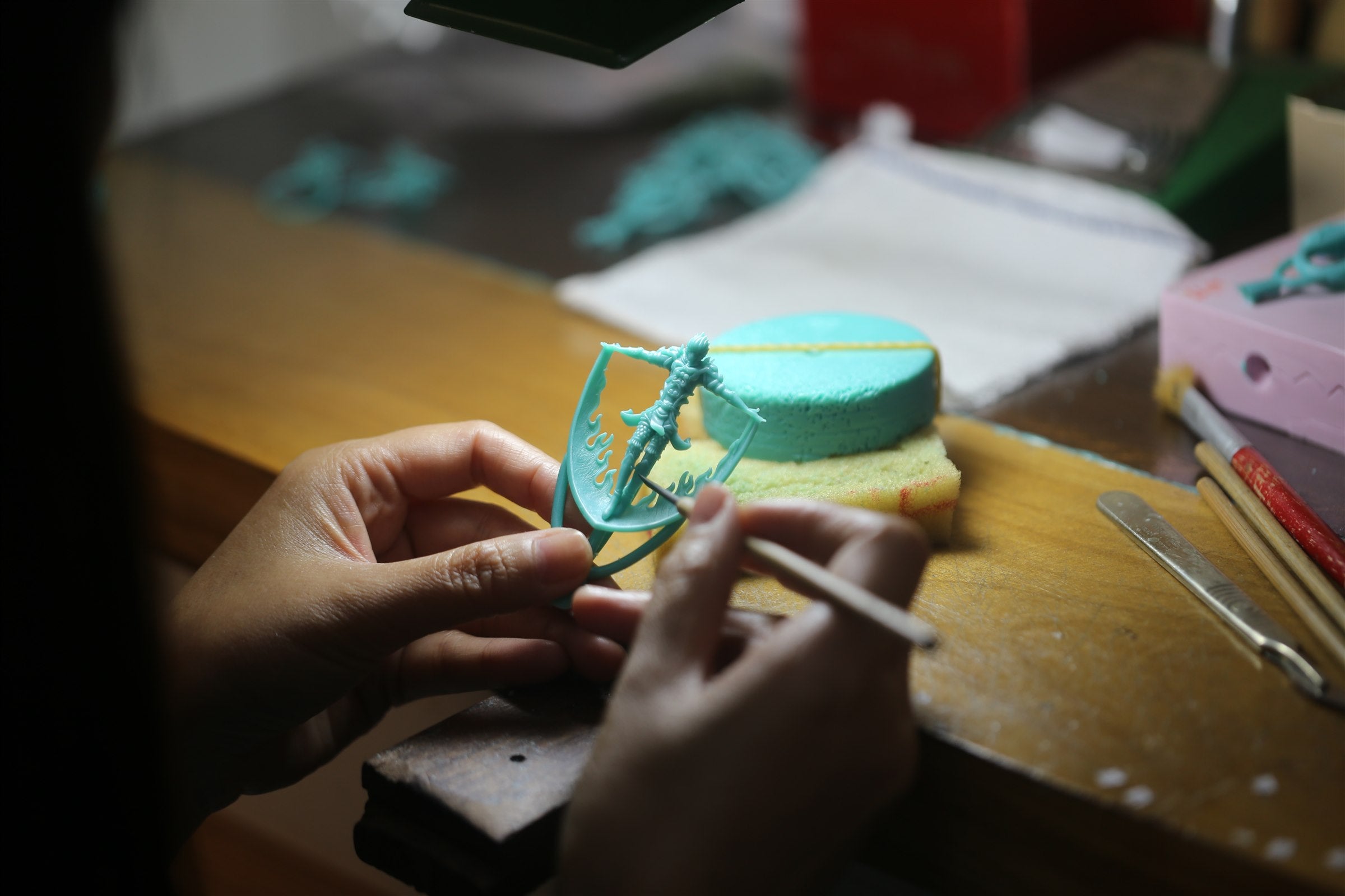 Artisan carving a Garuda form in wax by hand