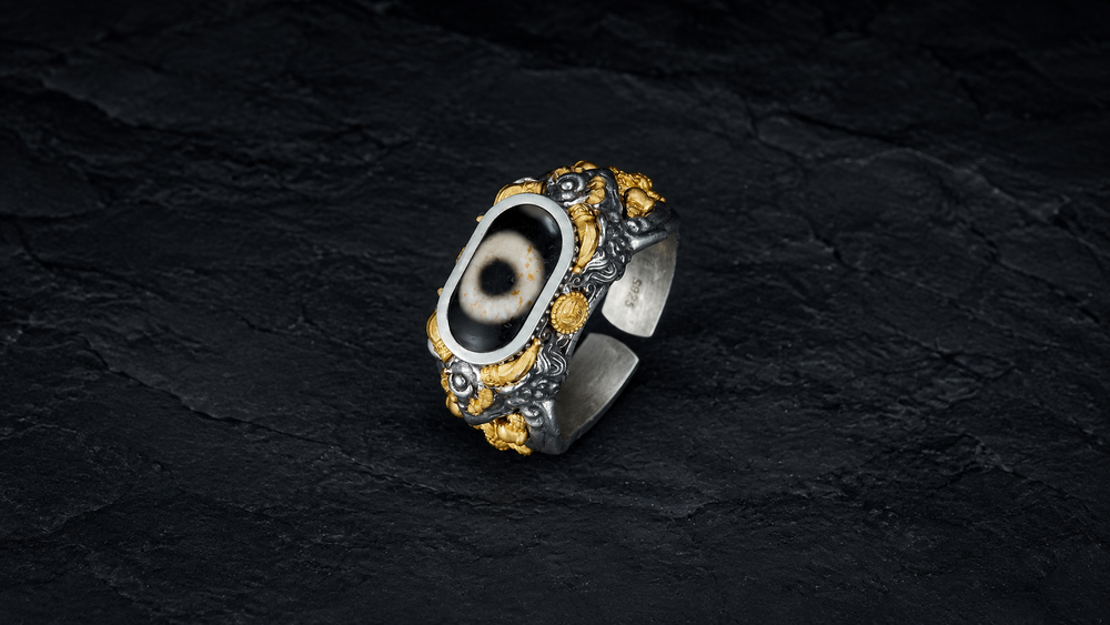 Centered full Dzi bead Garuda ring with an eye-pattern bead, open band, raised bird relief, and gold-toned accents