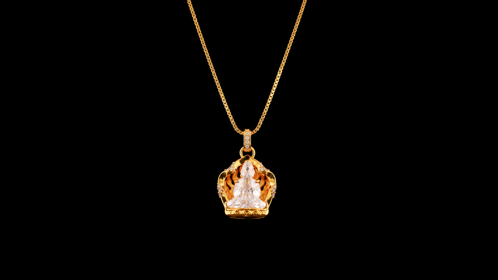 Gold-tone necklace with a stupa-shaped pendant, clear seated figure, flame-like surround, and lower base against a black background.