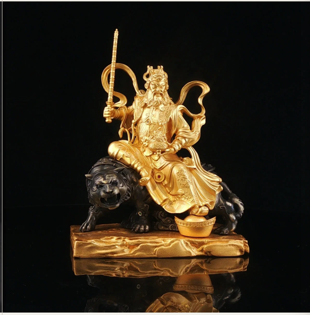 Gold-tone Zhao Gongming seated on a black tiger, holding a raised whip-like implement beside a gold ingot, against a black background.