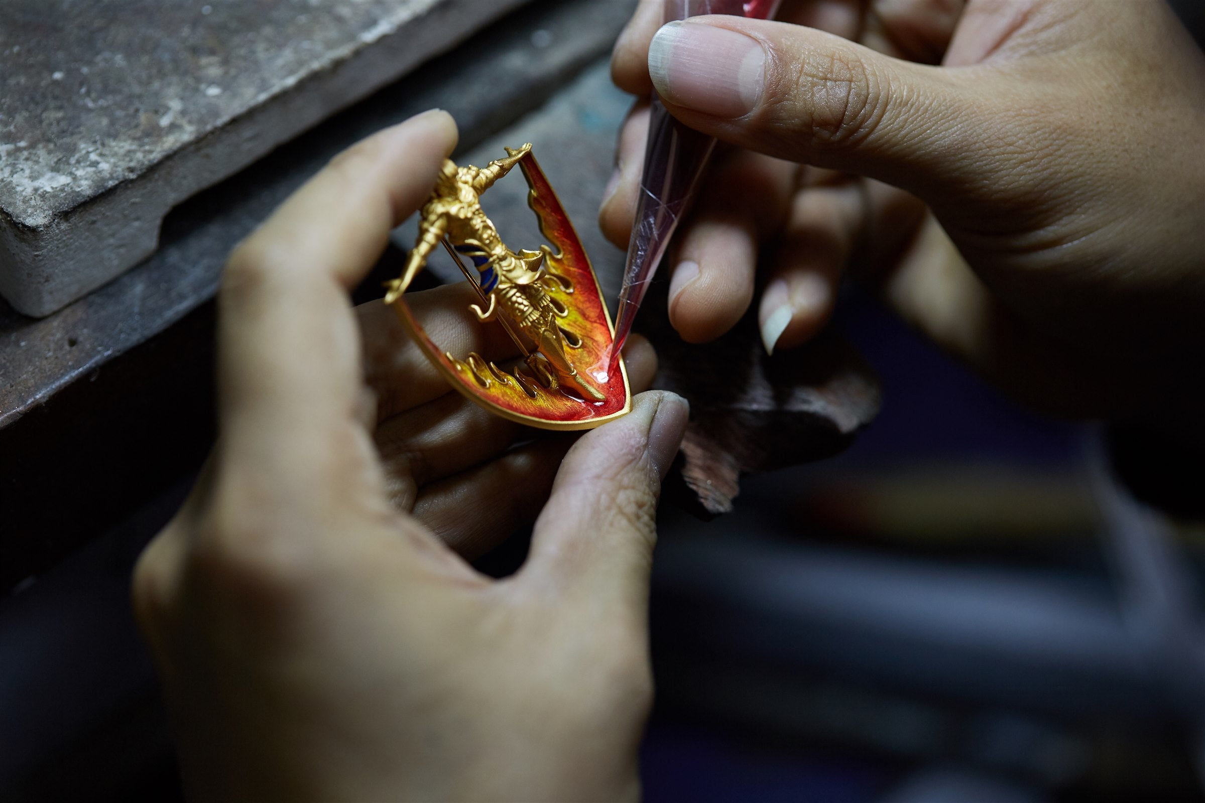 Red enamel being applied to the Garuda pendant